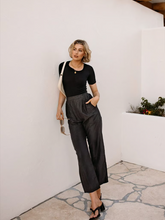 a lady wears a black t-shirt with black leather pants